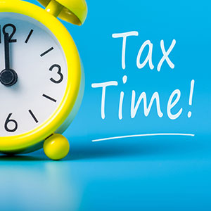 Tax Time yellow alarm clock and words Tax Time! next to it